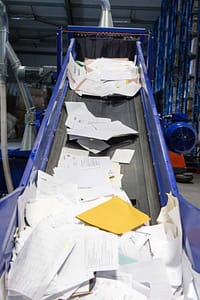 Paper going up the shredding conveyor ready to be shredded